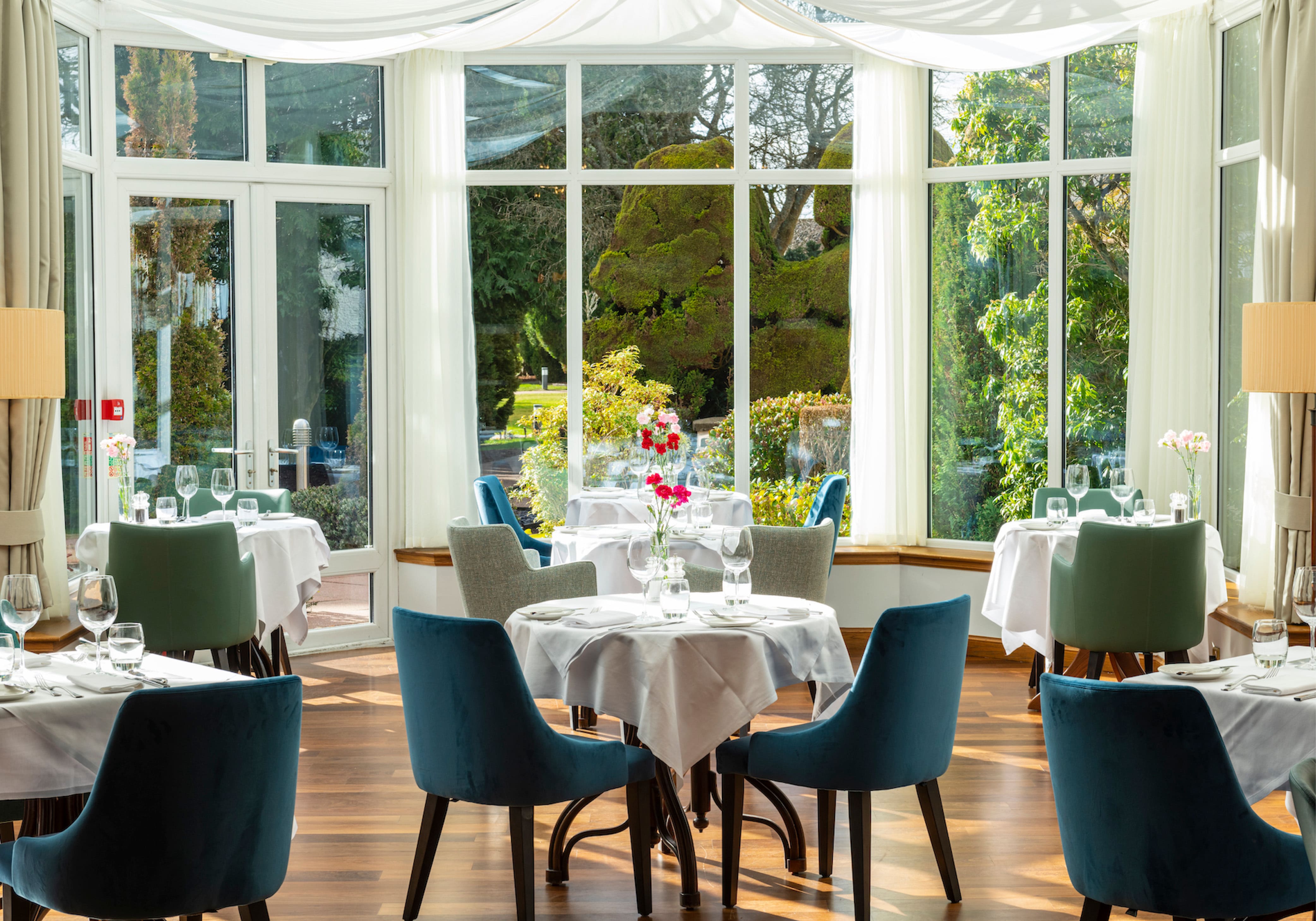 Tables at the Conservatory Restaurant with garden view at Kingsmills Hotel, Inverness