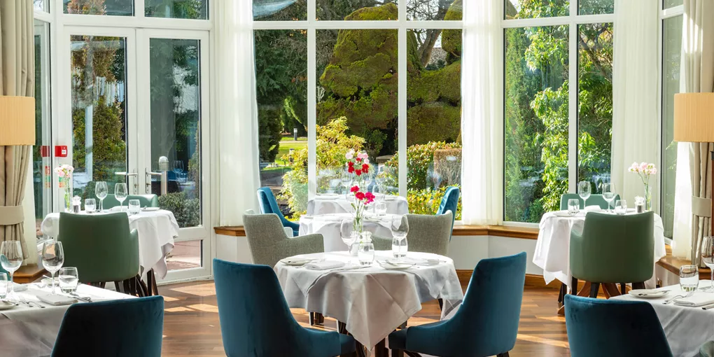 Tables at the Conservatory Restaurant with garden view at Kingsmills Hotel, Inverness